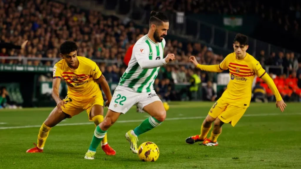 Real Betis' Isco in action with FC Barcelona's Lamine Yamal and Pedri 